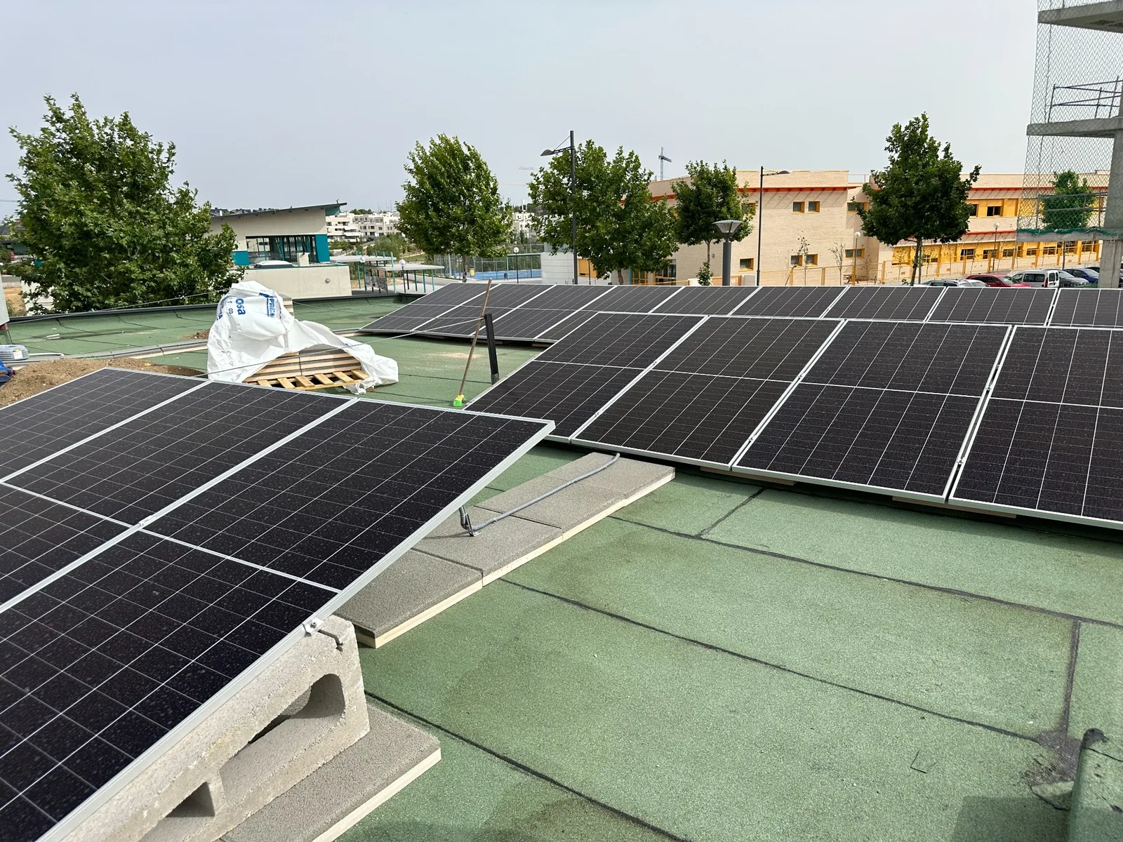 Módulos fotovoltaicos instalados progresivamente sobre la cubierta del polideportivo.